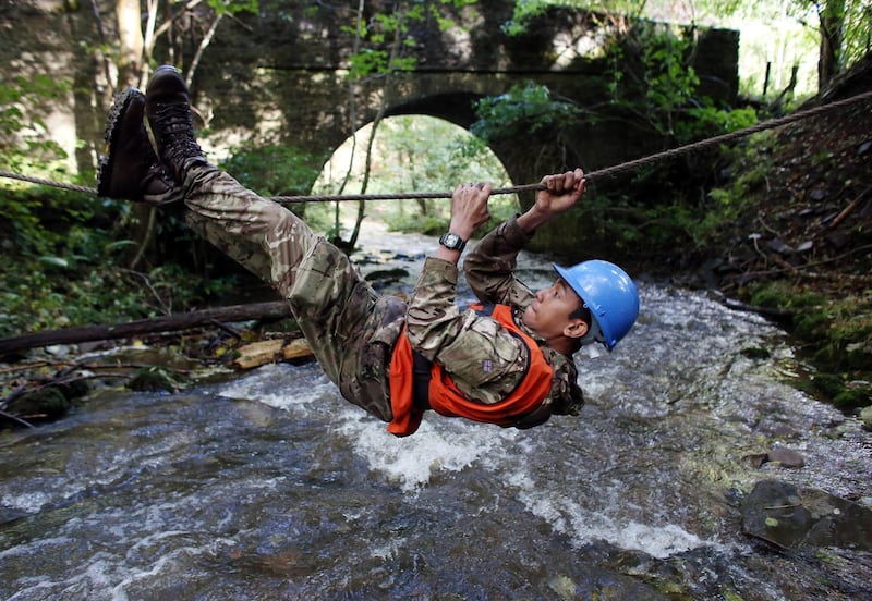 BRECON, WALES - OCTOBER 16:  A British Army officer cadet from the Royal Military Academy Sandhurst, crosses across a river during a command task as he takes part in Exercise Long Reach in the Brecon Beacons on October 16, 2013 near Brecon, Wales. The 36-hour, 50-mile march with kit, involves 200 cadets, six weeks into the junior term of their year-long course, being also made to conduct a number of command tasks, testing not only their physical endurance but also their mental ability when tired and under pressure. As a result, the exercise is seen as the officer cadets first major physical and mental hurdle of the Academys demanding training programme.  (Photo by Matt Cardy/Getty Images)