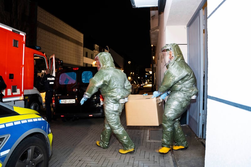 Investigators in protective suits remove items from a house in Castrop-Rauxel, western Germany. AP