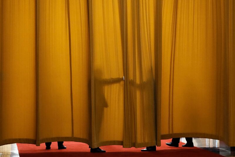 Guards keep a curtain closed before a meeting between France's President Emmanuel Macron and Chinese Premier Li Qiang at the Great Hall of the People in Beijing. AP
