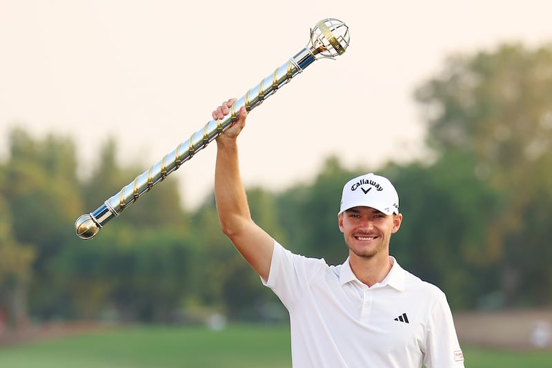 Nicolai Hojgaard of Denmark lifts the DP World Tour Championship trophy on the 18th green on the Earth Course at Jumeirah Golf Estates on November 19, 2023. Getty Images