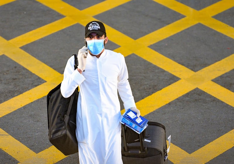 epa08383850 A Kuwaiti passenger wearing a face mask arrives at Kuwait international airport, in Kuwait city, Kuwait, 25 April 2020, 25 April 2020, during the coronavirus disease (COVID-19) pandemic. Kuwait is repatriating its citizens from abroad, the country's national aviation authority announced.  EPA/NOUFAL IBRAHIM