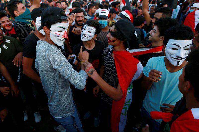 Demonstrators wearing masks attend an anti-government protest in Najaf. Reuters