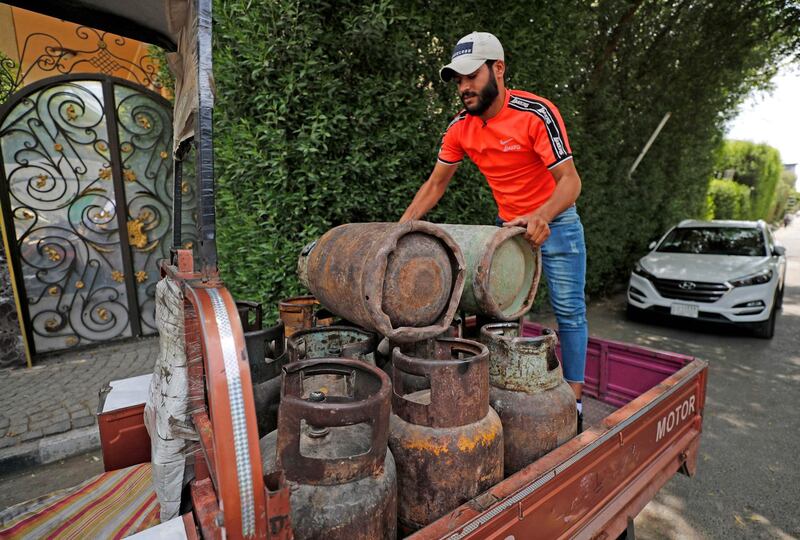 Mr Abbas unloads gas cylinders from his rickshaw. AFP