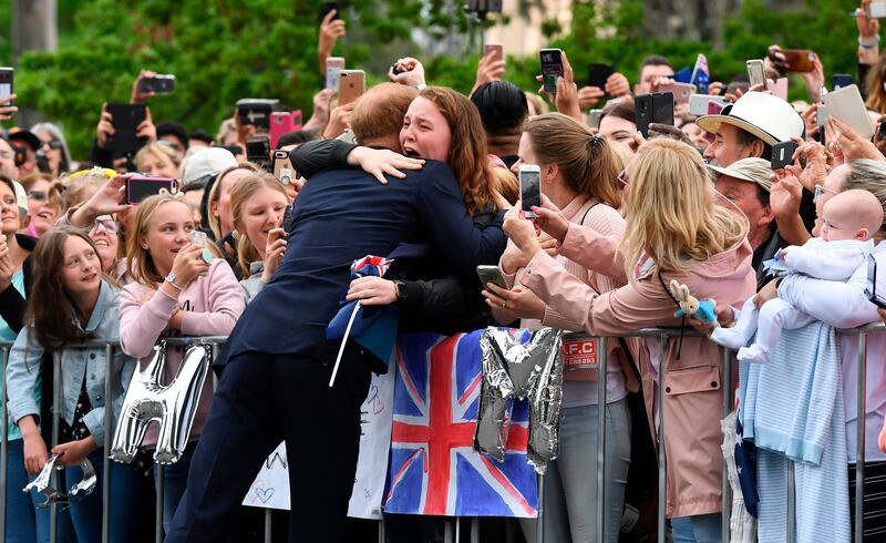 Britain's Prince Harry embraces India Brown during a public walk in Melbourne on October 18, 2018. Thousands of royal fans in Melbourne waited in the rain on October 18 to get a glimpse of Prince Harry and his pregnant wife Meghan, with some overwhelmed by the experience.  / AFP / POOL / WILLIAM WEST
