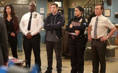 This image released by NBC shows the cast of the comedy series "Brooklyn Nine-Nine," from left, Stephanie Beatriz, Andre Braugher, Andy Samberg, Melissa Fumero and Joe Lo Truglio. In a world turned upside down by disease, TV viewership is growing.  Actress Julie Bowen of â€œModern Familyâ€ said she and her children binged on the NBC comedy, â€œBrooklyn Nine-Nine.â€(Jordin Althaus/NBC via AP)