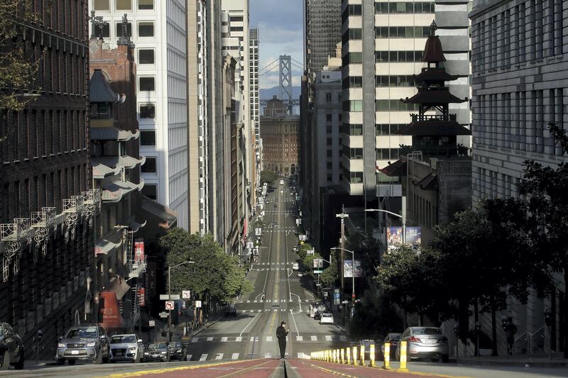 A man stands in the middle of a cable car tracks on a near empty California Street in San Francisco, Saturday, March 21, 2020. Some 40 million Californians are coping with their first weekend under a statewide order requiring them to stay at home to help curb the spread of the coronavirus(AP Photo/Jeff Chiu)