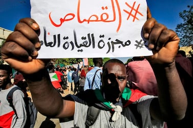 A Sudanese protester flashes a sign reading in Arabic "#Retribution, #GeneralCommandMassacre", during a demonstration in the centre of Sudan's capital Khartoum. AFP