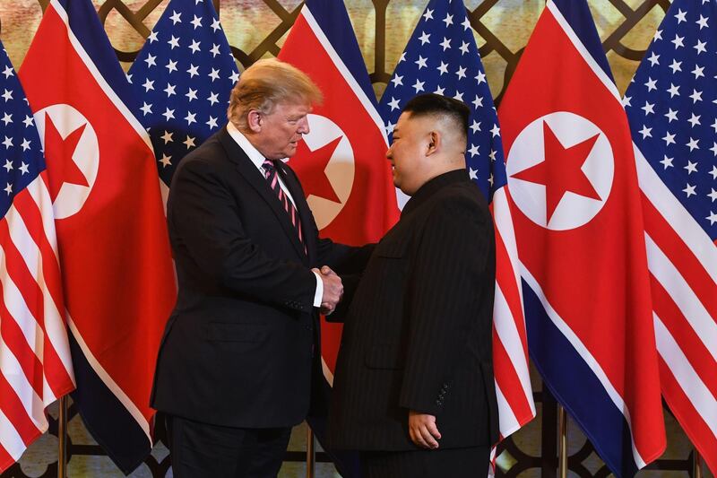 Donald Trump speaks with Kim Jong-un before a meeting. AFP
