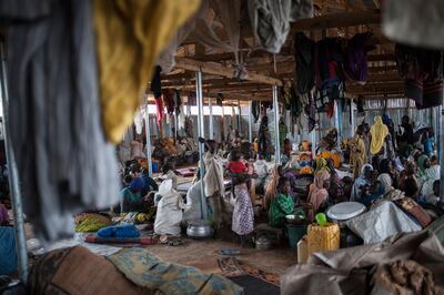 Newly arrived women and children sit amongst their belongings in a structure erected for newly arrived IDPs (Internally Displaced People) in Pulka on August 1, 2018. - As the presidential race heats up ahead of February polls, the Nigerian government and officials of Borno state, the epicentre of the Boko Haram Islamist insurgency, are encouraging and facilitating the "return" of tens of thousands of people. As he campaigns for a second term in office, the incumbent president is working to show that he has delivered on his pledge to defeat the Islamists. But the reality is that people are being sent back to camps across Borno state while Boko Haram is still launching devastating attacks against military and civilian targets. Pulka is a garrison town built on a model becoming increasingly common across Nigeria's remote northeast region: a devastated town turned into a military base so soldiers can protect satellite camps and humanitarian agencies can distribute aid. (Photo by Stefan HEUNIS / AFP)
