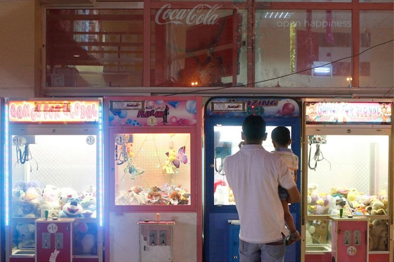 A man and his child peruse arcade games at a rest area atop Jebel Hafeet in Al Ain. Sarah Dea / The National