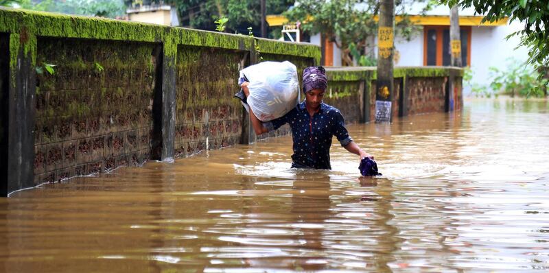 A young man wades through a flooded street in Kochi, Kerala state, India. According to reports, the region is on a high alert with schools and offices been closed due to the rising water levels of Periyar river after the gates of the Idukki reservoir were opened. The Indian state of Kerala has been hit by heavy rains that caused floods and reportedly killed at least 20 people.  EPA