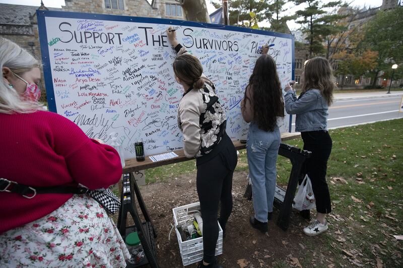 Those attending the vigil add their signatures to a board in support of survivors of sexual abuse. Getty / AFP
