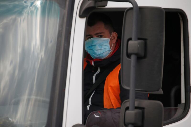 A truck driver wearing a protective face mask arrives at the Amazon logistics center in Lauwin-Planque, northern France, March 19, 2020. Several hundred employees protested in France, calling on the U.S. e-commerce giant to halt operations or make it easier for employees to stay away during the coronavirus (COVID-19) epidemic. REUTERS/Pascal Rossignol