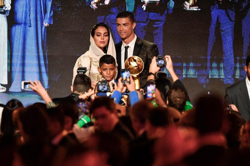 Juventus' Portuguese forward Cristiano Ronaldo (C), holding his "Best Player of the Year 2018 Award" poses his companion Georgina Rodriguez (L) and his son Cristiano Jr during the 10th edition of the Dubai Globe Soccer Awards. AFP