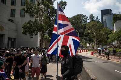HONG KONG, CHINA - SEPTEMBER 15: Pro-democracy protesters wave 
flags and chant slogans outside the UK embassy on September 15, 2019 in Hong Kong, China. Pro-democracy protesters have continued demonstrations across Hong Kong, calling for the city's Chief Executive Carrie Lam to immediately meet the rest of their demands, including an independent inquiry into police brutality, the retraction of the word riot to describe the rallies, and genuine universal suffrage, as the territory faces a leadership crisis. (Photo by Chris McGrath/Getty Images)