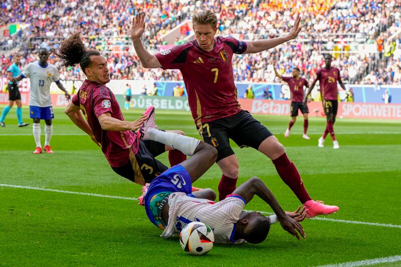 France's Marcus Thuram tangles with Belgium's Kevin De Bruyne and Arthur Theate. AP 