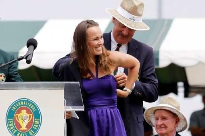 Don't be fooled by the awkward way Martina Hingis, left, had her Tennis Hall of Fame jacket is slipped on to her by fellow Hall of Famer Stan Smith, right. The Swiss was all grace and guile during her best years on the courts.
