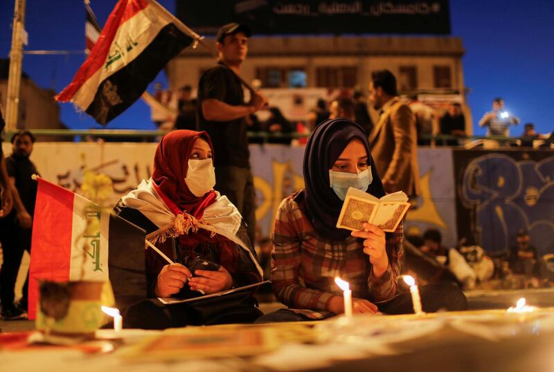 Demonstrators read Quran and light up candles for the people killed at an anti-government protest in Iraq, in Baghdad. REUTERS