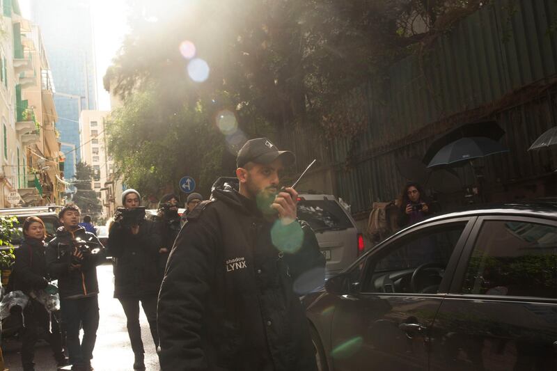 A private security guard speaks on a radio as a vehicle approaches the house of ex-Nissan chief Carlos Ghosn in Beirut, Lebanon. AP Photo