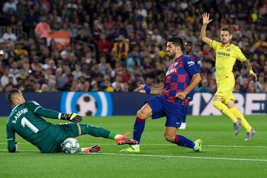 Barcelona's Uruguayan forward Luis Suarez (R) kicks the ball in front of Villarreal's Spanish goalkeeper Sergio Asenjo (L) during the Spanish league football match between FC Barcelona and Villarreal CF at the Camp Nou stadium in Barcelona, on September 24, 2019. / AFP / LLUIS GENE