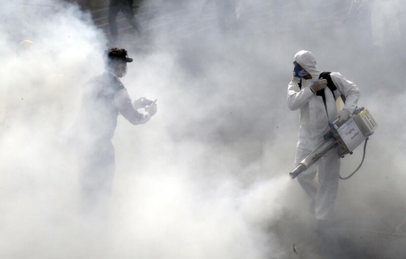 Firefighters disinfect streets in an effort to halt the spread of coronavirus in Tehran, March 13. EPA