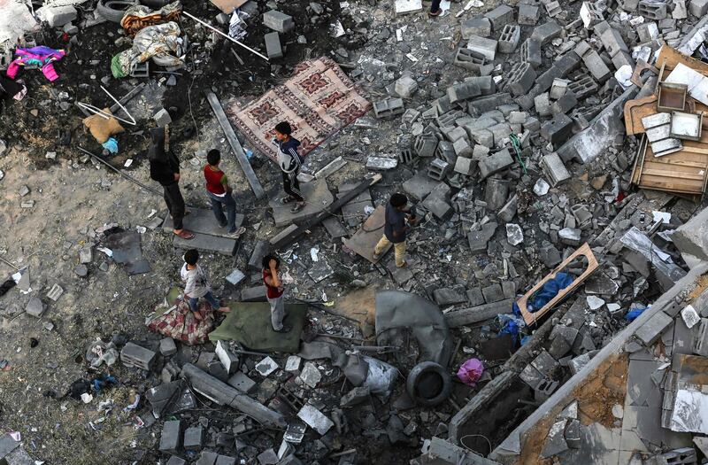 Palestinians children gather among the rubble. AFP