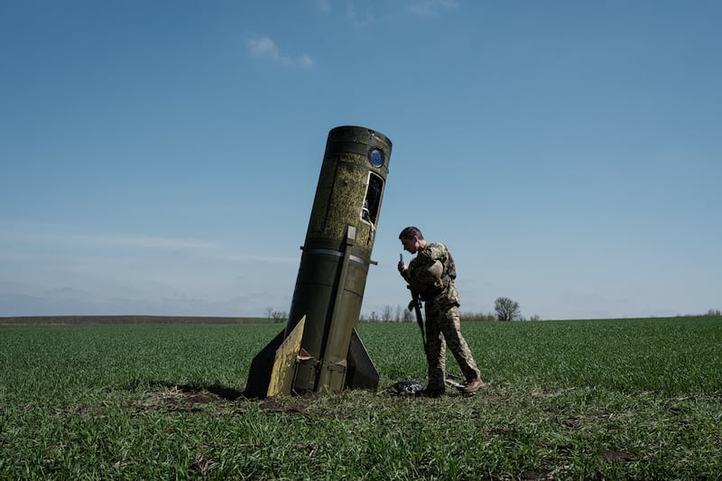 A Ukrainian serviceman looks at a Russian ballistic missile's booster stage that fell in a field in Bohodarove, eastern Ukraine, on April 25. AFP