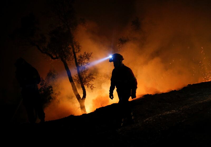 A firefighter works to put out a forest fire in Cabanoes, near Lousa, Portugal. Pedro Nunes / Reuters