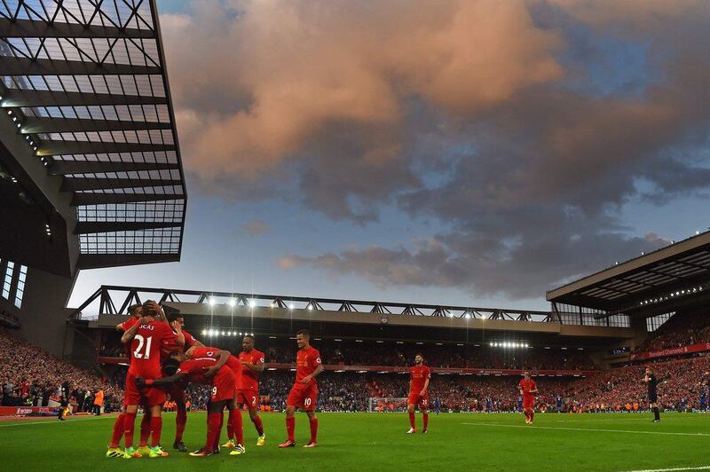 Liverpool players celebrate after Roberto Firmino scores their fourth goal against Leicester City. Paul Ellis / AFP