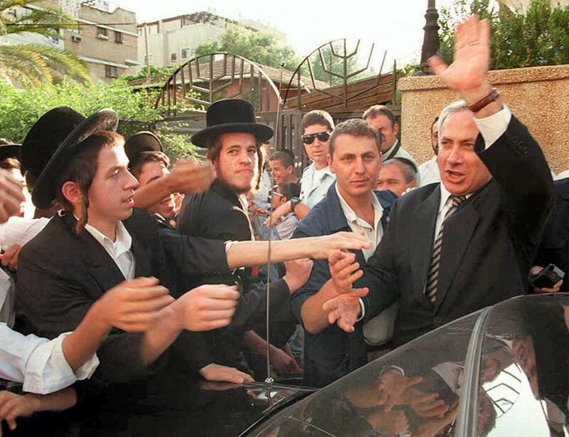Israeli right-wing Likud party leader Benjamin "Bibi"Netanyahu (R) shakes hands with ultra orthodox students of a religious school in Benibrak a religious town near Tel Aviv 22 May. Netanyahu is Prime Minister Shimon Peres' main challenger in the upcoming 29 May elections.  AFP PHOTO Yoav LEMMER (Photo by YOAV LEMMER / AFP)