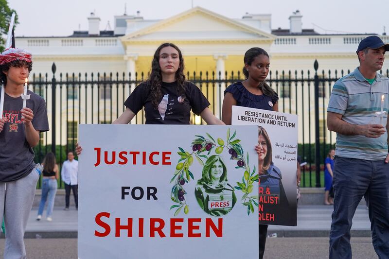 A woman holds a Justice for Shireen sign at a candlelight vigil for Palestinian journalist Shireen Abu Akleh outside of the White House. Willy Lowry / The National