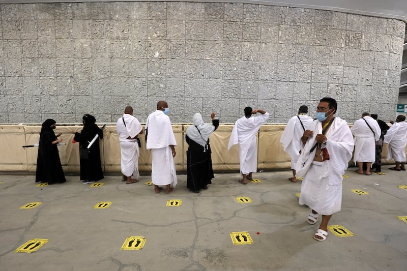 Pilgrims throw stones at pillars symbolising Satan during Hajj in Mina, near Makkah, Saudi Arabia.