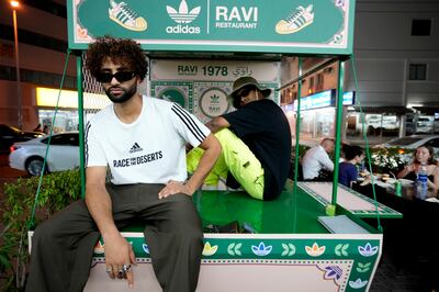 People pose for photos with the Ravi x Adidas truck in front of the Ravi restaurant in 2022. AP