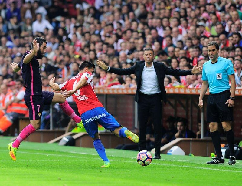 Barcelona midfielder Arda Turan vies with Sporting Gijón midfielder Sergio Alvarez. Ander Gillenea / AFP