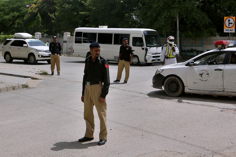 Police officers stand guard while the England cricket team arrive at their hotel in Karachi. AP Photo