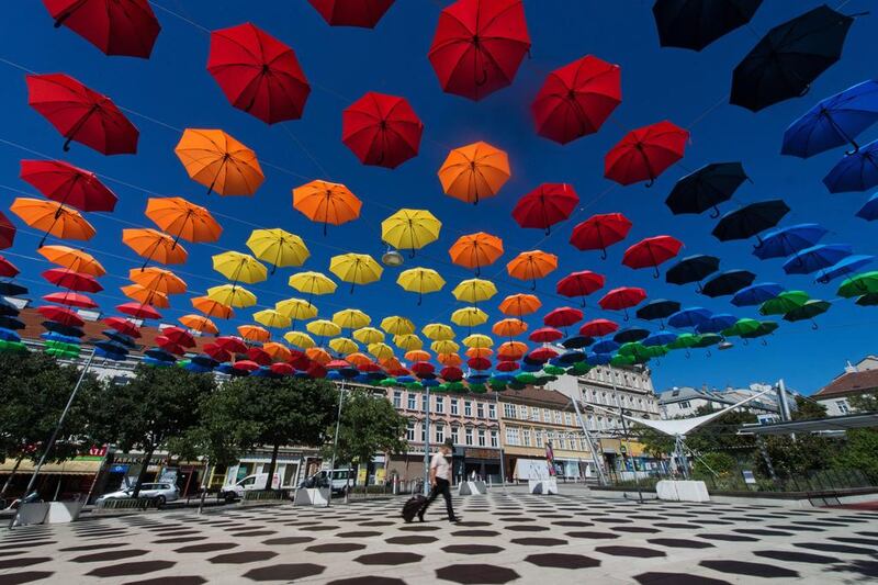 A man walks under spectral coloured umbrellas of the art installation ‘REGEN.WALD’ (rain.forest) in Vienna, Austria. The installation is part of the annual cultural projects ‘space and place’ and ‘Vienna lives’. Christian Bruna / EPA