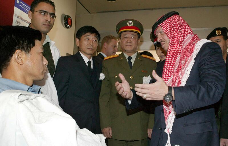 King Abdullah visits a wounded Chinese citizen at a hospital in Amman in November 2005. Three Chinese were killed and one wounded in suicide attacks in the city. AFP