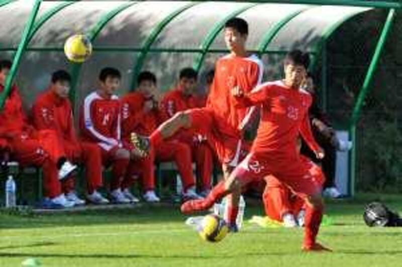 North Korean footballers Kim Myong Won (L) and Ri Chol Myong (R) practice, on October 14, 2009, at a local football technical center, in Saint-Sebastien-sur-Loire, western France, during a training mission in France that could help strained relations between the two countries.This delegation of 19 players and nine coaches and officials arrived on October 5, 2009 for what will be North Korea's last official football trip to Europe before they go to the 2010 World Cup in South Africa next year. AFP PHOTO FRANK PERRY 

