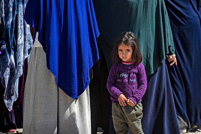 A child stands in front of veiled women at Camp Roj, in Syria's northeastern Hasakah province, where relatives of people suspected of belonging to ISIS are held. AFP