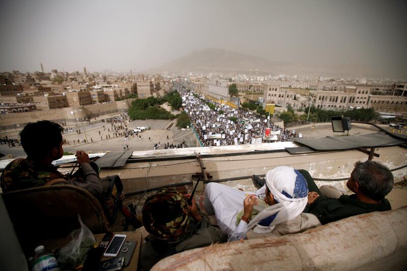 REFILE - CORRECTING GRAMAR Houthi fighters watch from the roof of a building as they secure the site of a rally attended by supporters to mark the anniversary of launching their motto (Sarkha), in which they call for the "Death of America and Israel", in Sanaa, Yemen July 13, 2018. REUTERS/Mohamed al-Sayaghi??