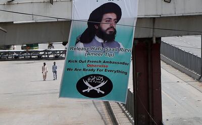 A banner of demands with a portrait of Saad Rizvi, the leader of Tehreek-e-Labiak Pakistan, a radical Islamist political party, hangs on a bridge while his supporters block a road during a sit-in protest against the arrest of Rizvi, in Lahore, Pakistan, Wednesday, April 14, 2021. Pakistani security forces swinging batons and firing teargas moved before dawn Wednesday to clear sit-ins by protesting Islamists in the garrison city of Rawalpindi and elsewhere after five people died in earlier clashes, officials said. (AP Photo/K.M. Chaudary)