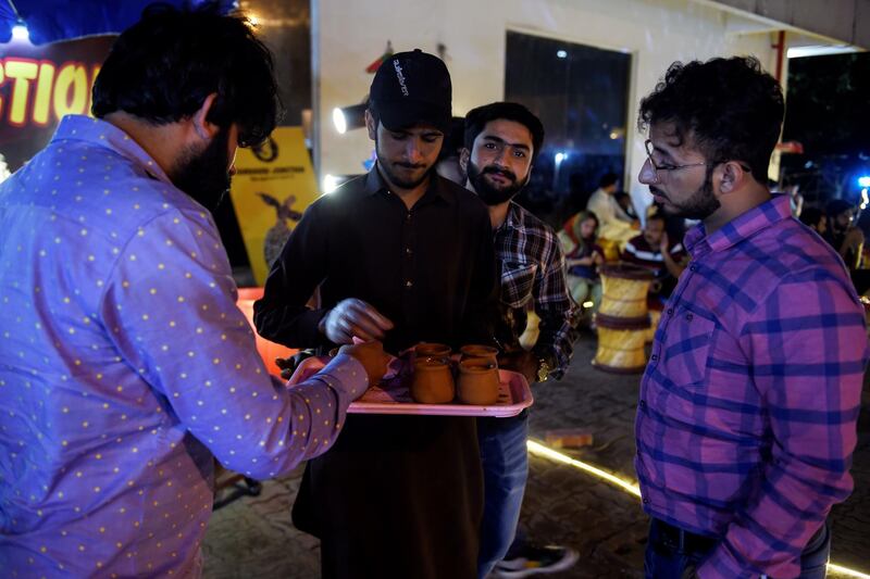 Pakistani people gather to drink tandoori tea in clay pots at a market in Islamabad. It's a cuppa like no other. Every evening in Islamabad a crowd arrives at Sanaullah's street stall to taste his "tandoori chai" - milk tea served in terracotta mugs, still hot from his traditional oven. The old-fashioned cups are placed directly inside the tandoor, where they are baked at high temperatures. Photo: AFP