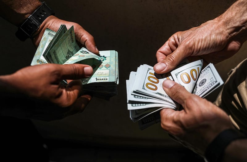 People exchange Lebanese pound and US dollar notes on the black market in Lebanon's capital Beirut on June 18, 2020.  / AFP / JOSEPH EID
