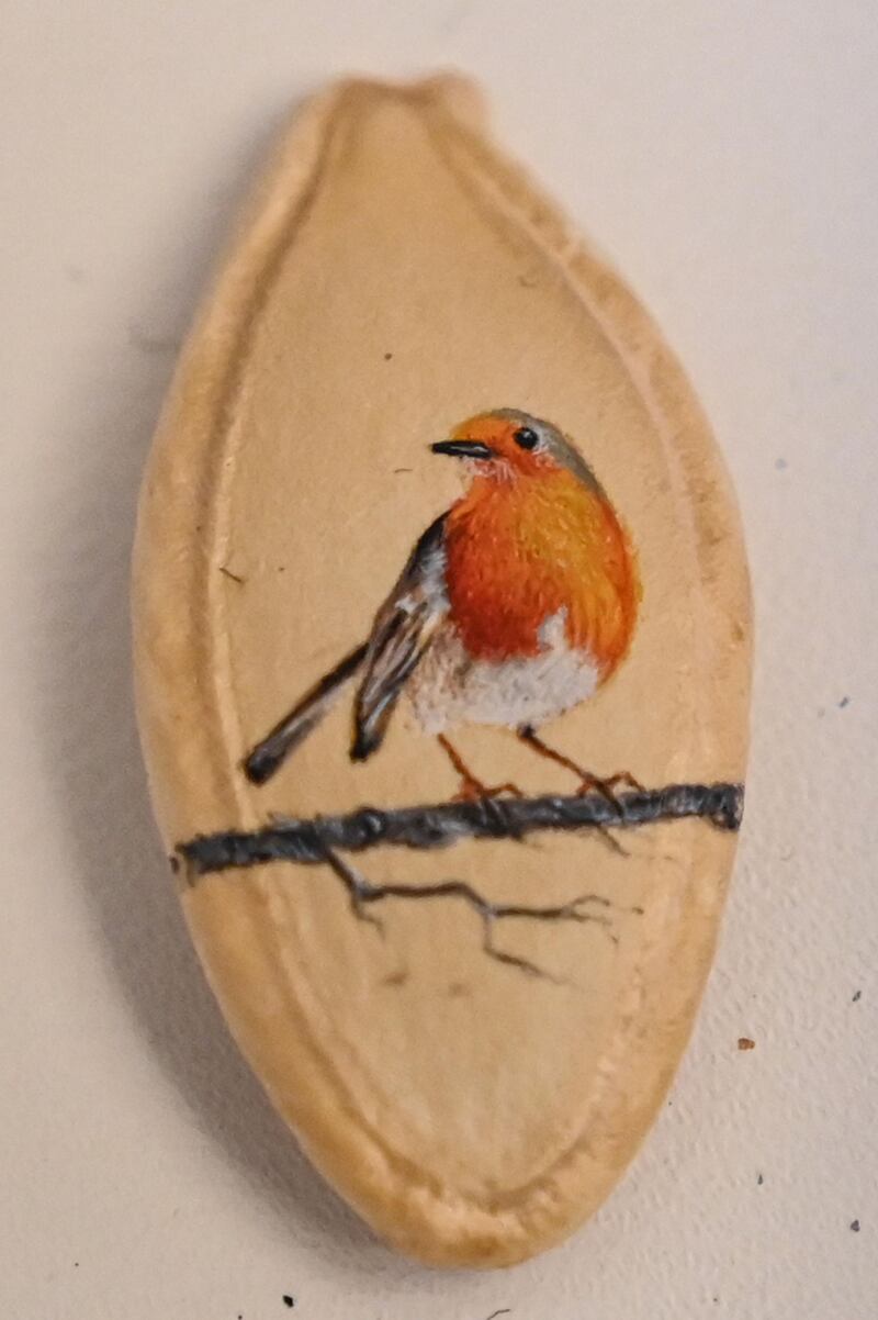 A bird painted on a pumpkin seed