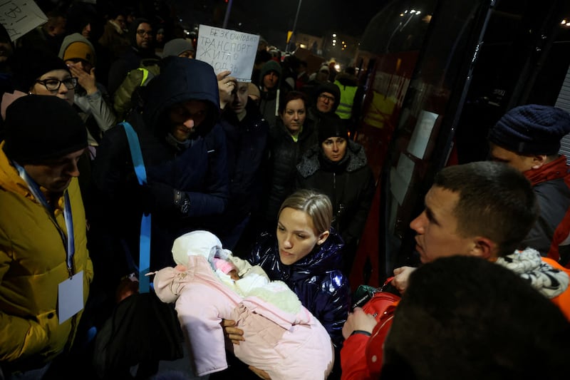 Oksana, 30, holds a seven-day-old child after arriving by bus at a rendezvous point organised to help Ukrainian refugees with  accommodation and transport to different cities in Poland. Reuters