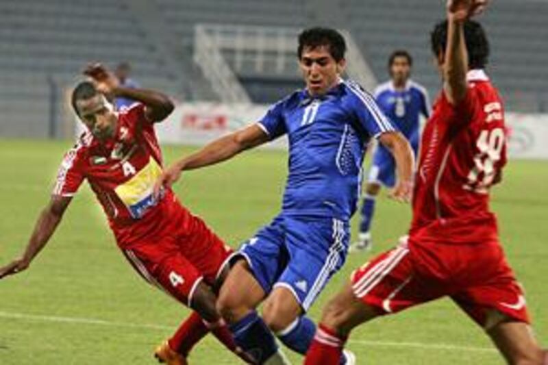 Nasr's Mehrzad Madanchi, in blue, tries to get between two Al Ahli players.