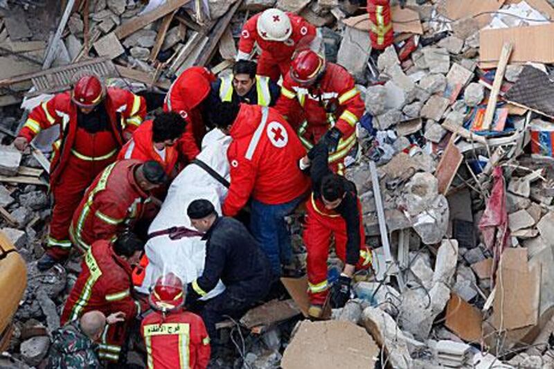 Rescue workers carry a body found under the debris of a collapsed building in the Fassouh area of the Lebanese capital.