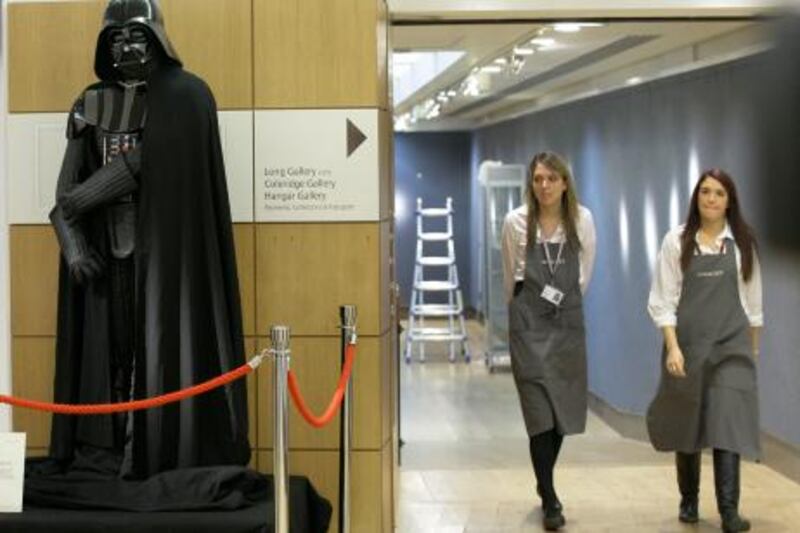 Christie's employees walk past a Darth Vader costume from the epic 'Star Wars' movie anthology on display during the 'Popular Culture : Film and Entertainment' sale at Christie's auction house in London, Thursday, Nov. 25, 2010.  The Darth Vader costume sold for a hammer down price of 150,000 pounds (US$236,700 or 177,300 euro)  (AP Photo/Sang Tan)