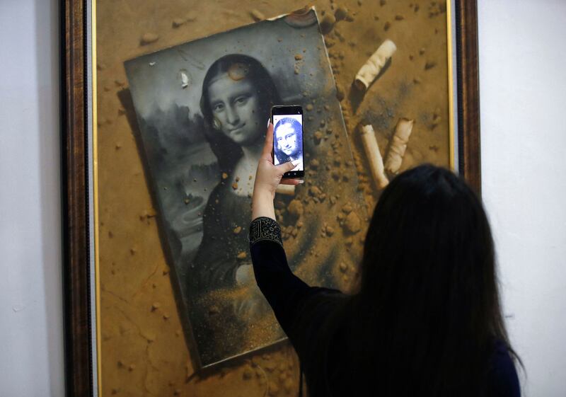 A gallery visitor takes a picture at an art exhibition for contemporary Iraqi artists organised yearly by the Iraqi Plastic Artist Society in the capital Baghdad. All photos by AFP