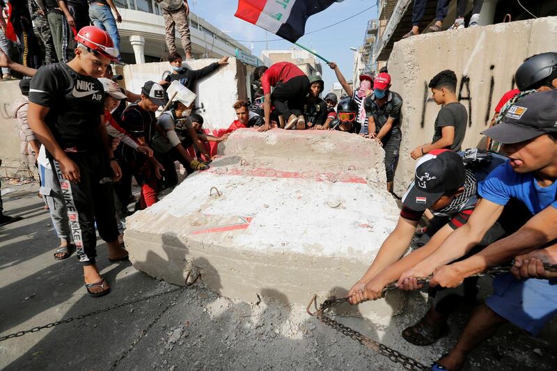 Demonstrators push down concrete walls during the ongoing anti-government protests, in Baghdad, Iraq. Reuters